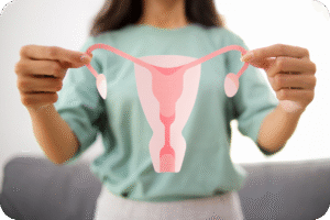 Mulher segurando um recorte de papel em formato de útero, trompas de Falópio e ovários, simbolizando a saúde reprodutiva feminina e ginecológica.